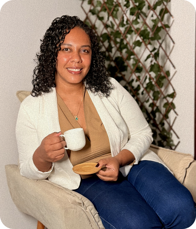 Retrato de Kayene Santiago sentada em uma poltrona segurando uma xícara