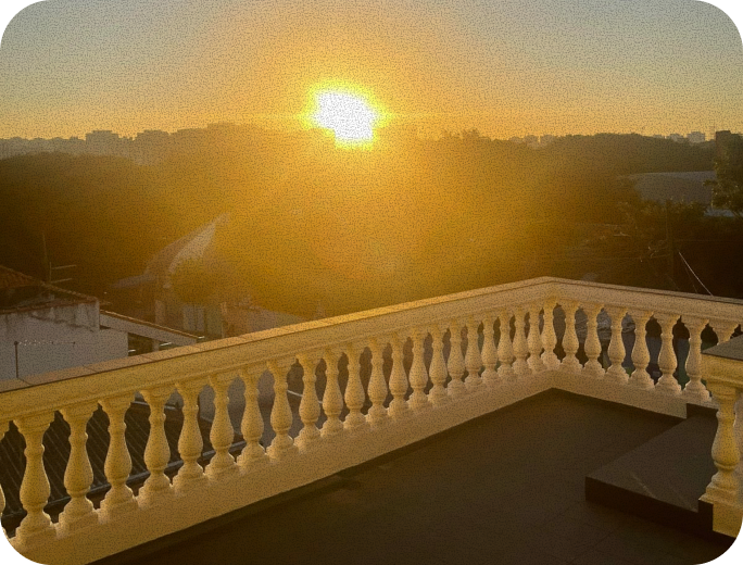 Vista do terraço do espaço ao pôr do sol, com o céu dourado sobre as árvores de São Bernardo do Campo